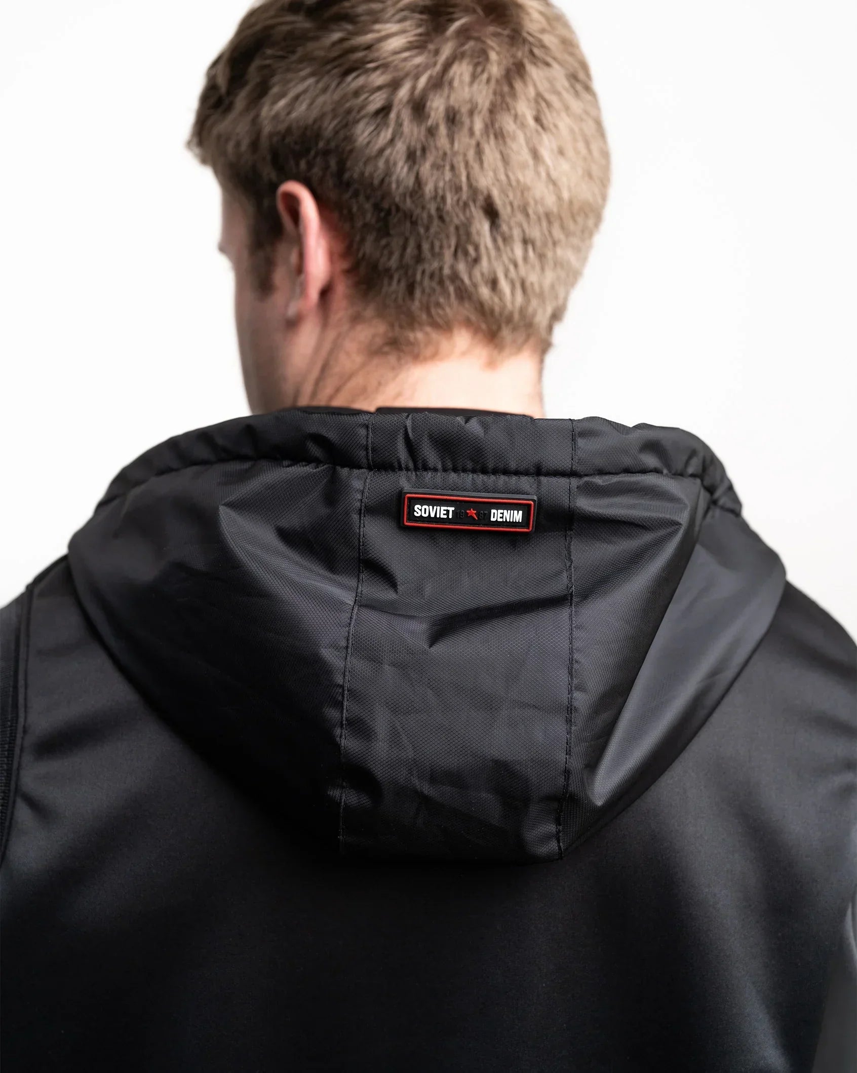 Black hooded padded gilet with zip front and small chest patch