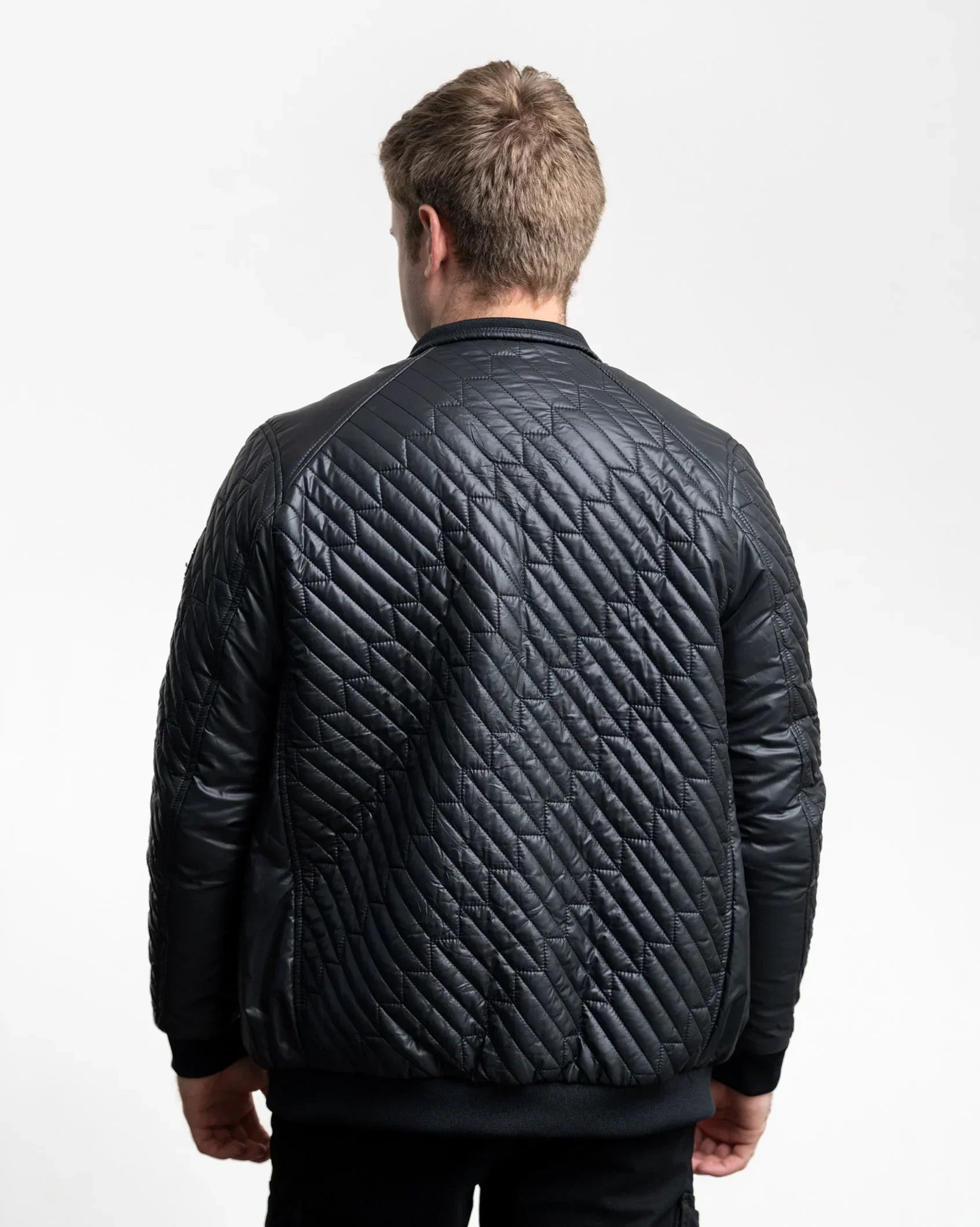 Black quilted men's jacket with stand collar and full-zip front, long sleeves.