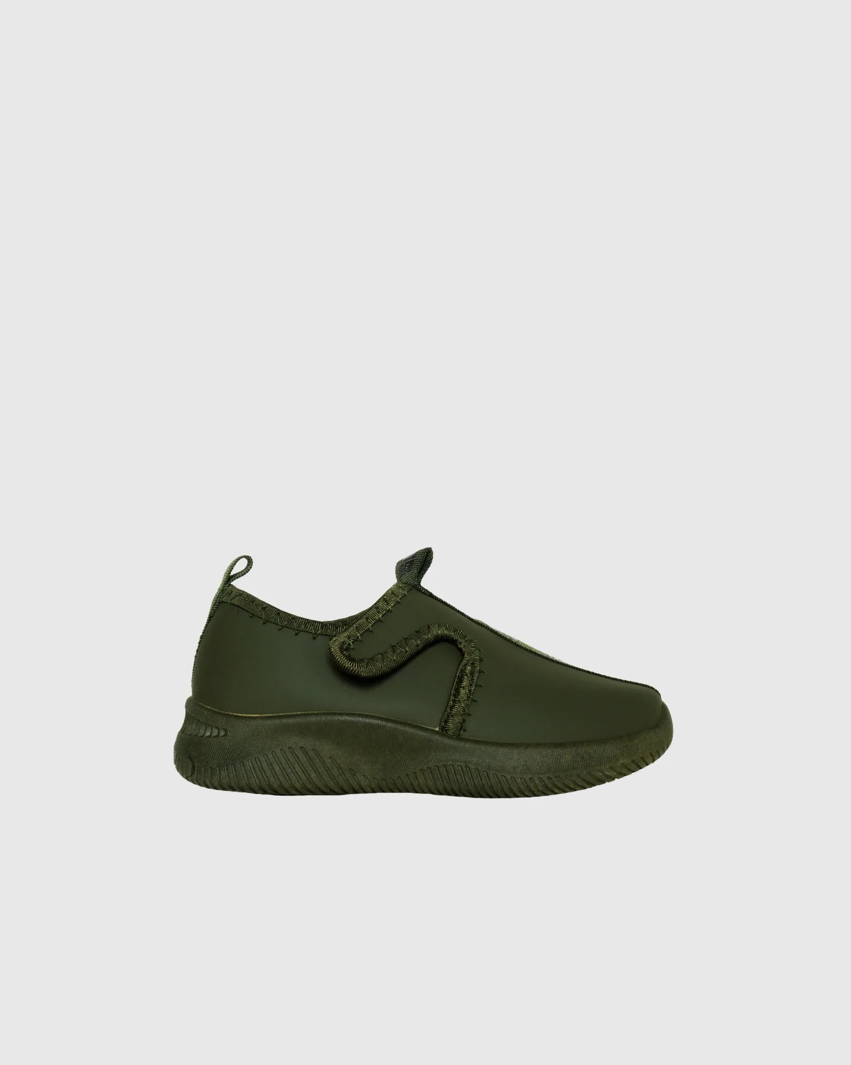 Olive green slip-on sneaker with velcro strap and textured sole on white background