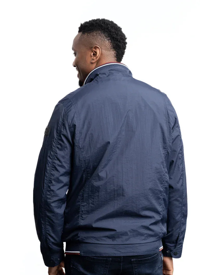 Men's lightweight jacket in navy from the back; zip front and striped hem trim.
