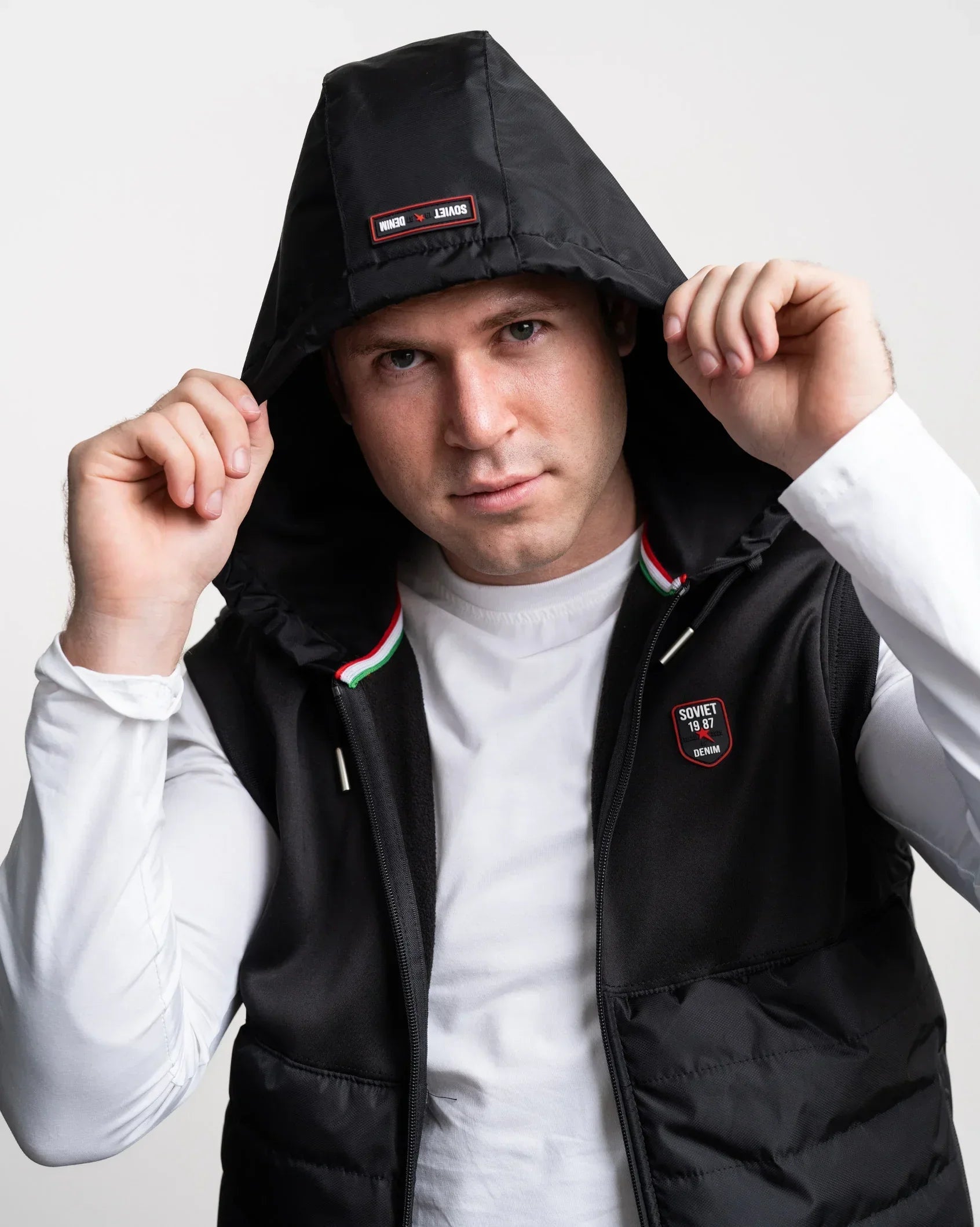 Black hooded gilet with drawstring, zip front, and striped trim at inner edge