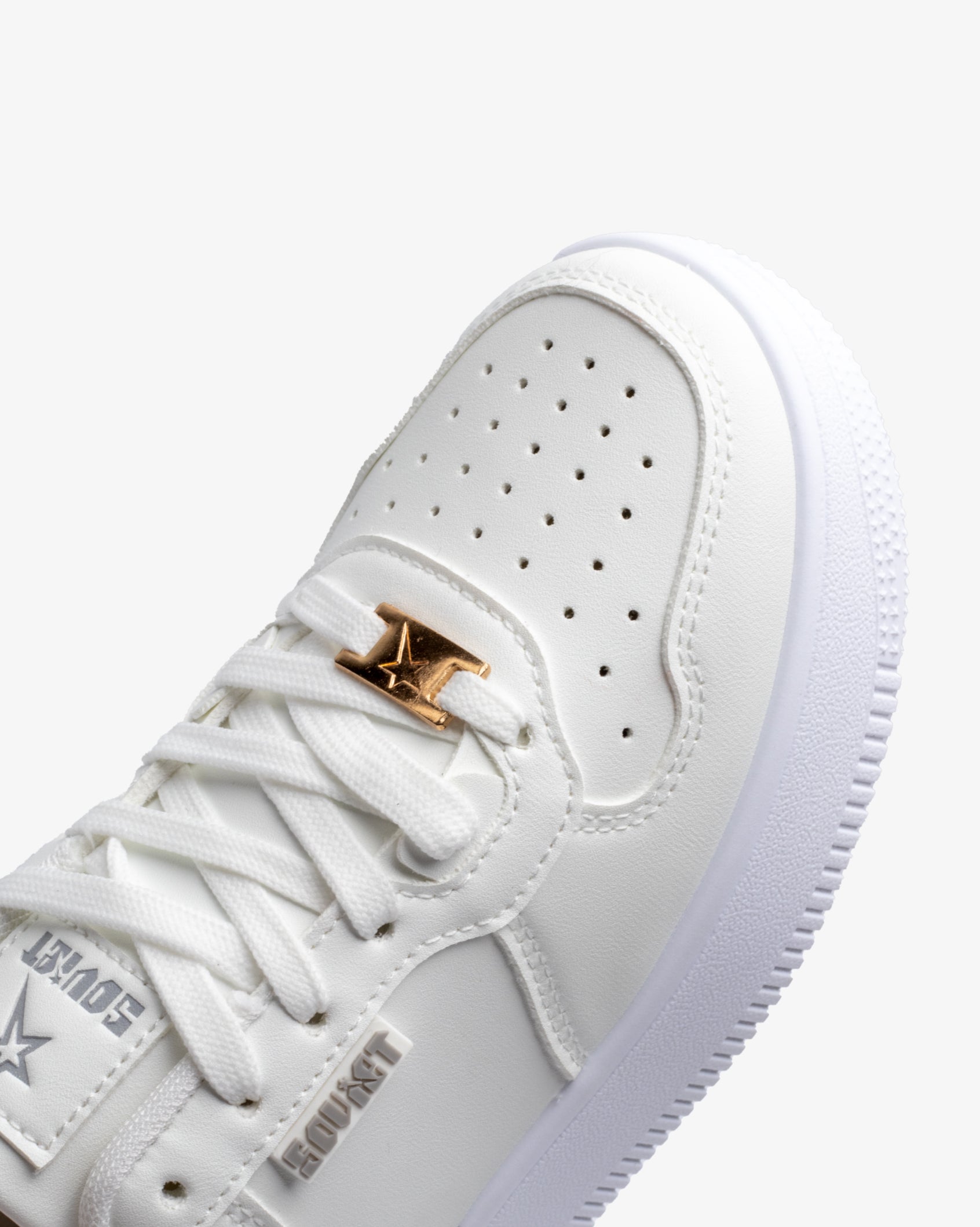 White PU sneaker detail: lace-up with perforated toe and gold logo emblem