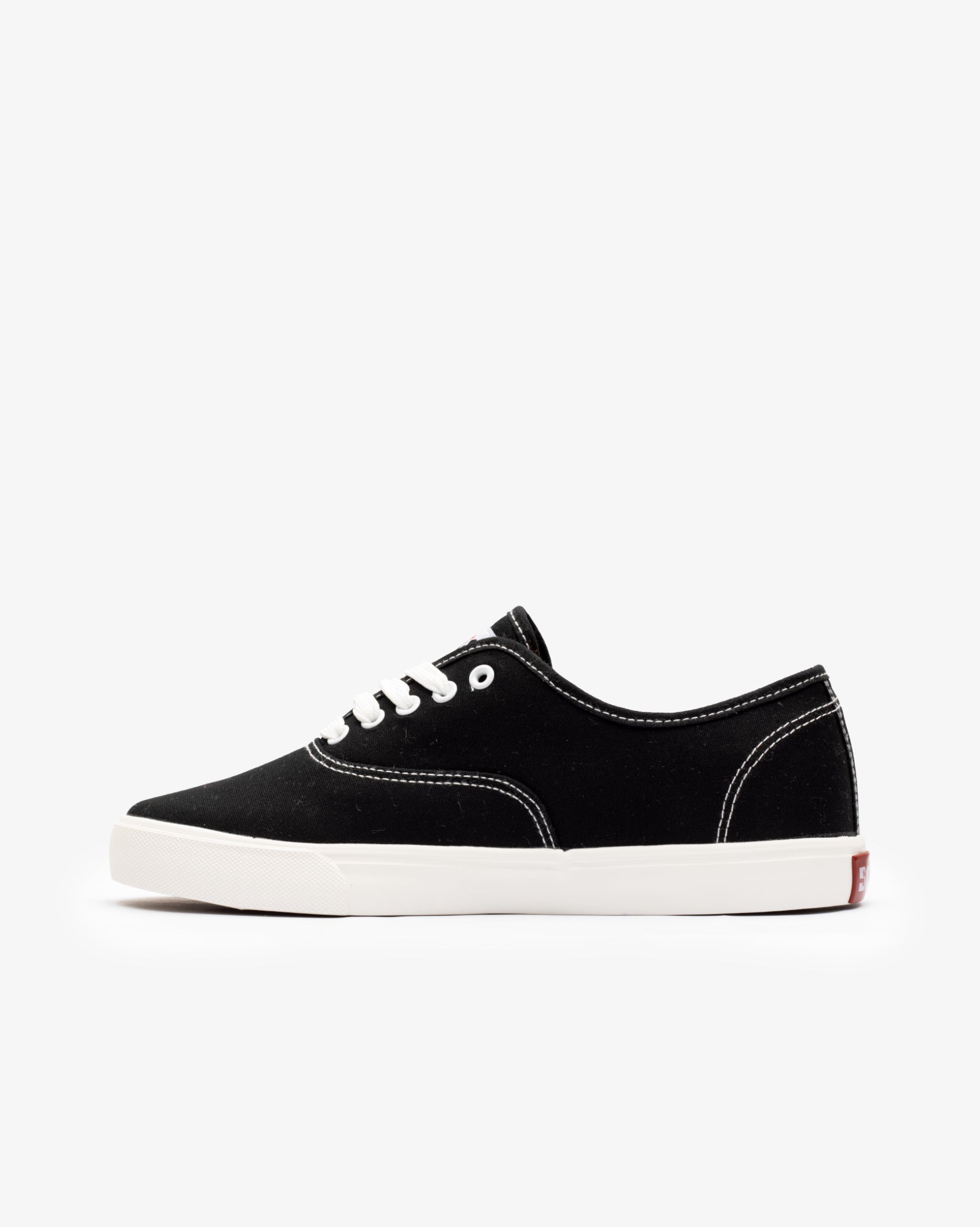 Men's low-cut canvas sneakers, black; angled side view with white laces and sole.