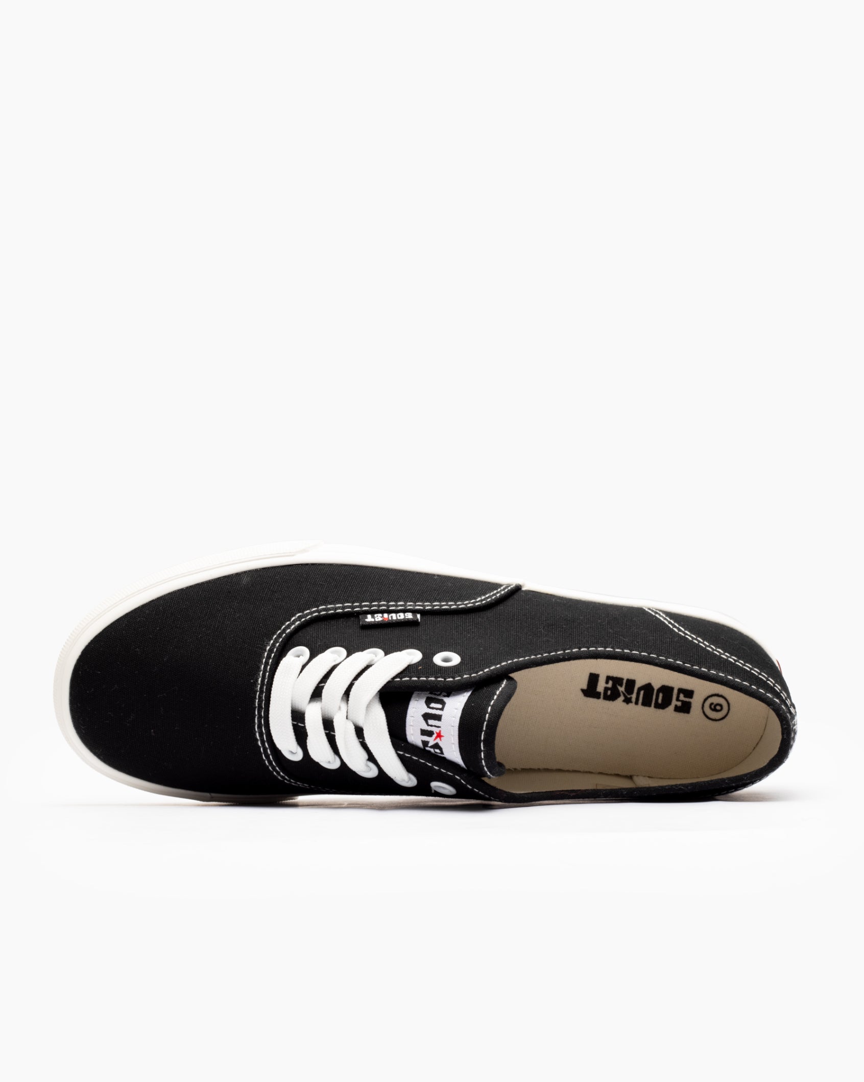 Men's low-cut canvas sneakers, black; interior lining and lace eyelets visible.